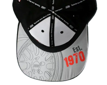 Load image into Gallery viewer, Inside view of BBS cap showing grey RT88 wheel drawing and red &quot;Est. 1970&quot; text on the underside of the visor.
