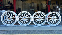 Load image into Gallery viewer, Set of four 16-inch BBS RG-F wheels, 4x100 bolt pattern, brilliant silver finish, ideal for E30 BMWs, showcased in a workshop.
